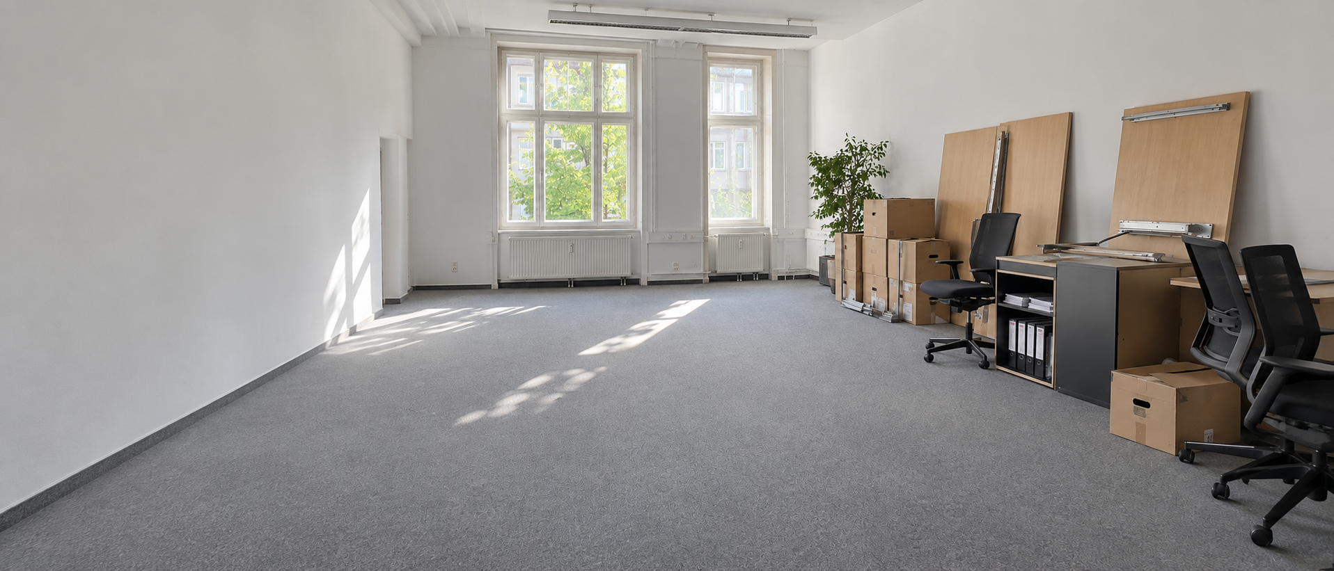 Bürofläche mit Kartons und bereitgestelltem Büromobiliar für eine Betriebsauflösung.
