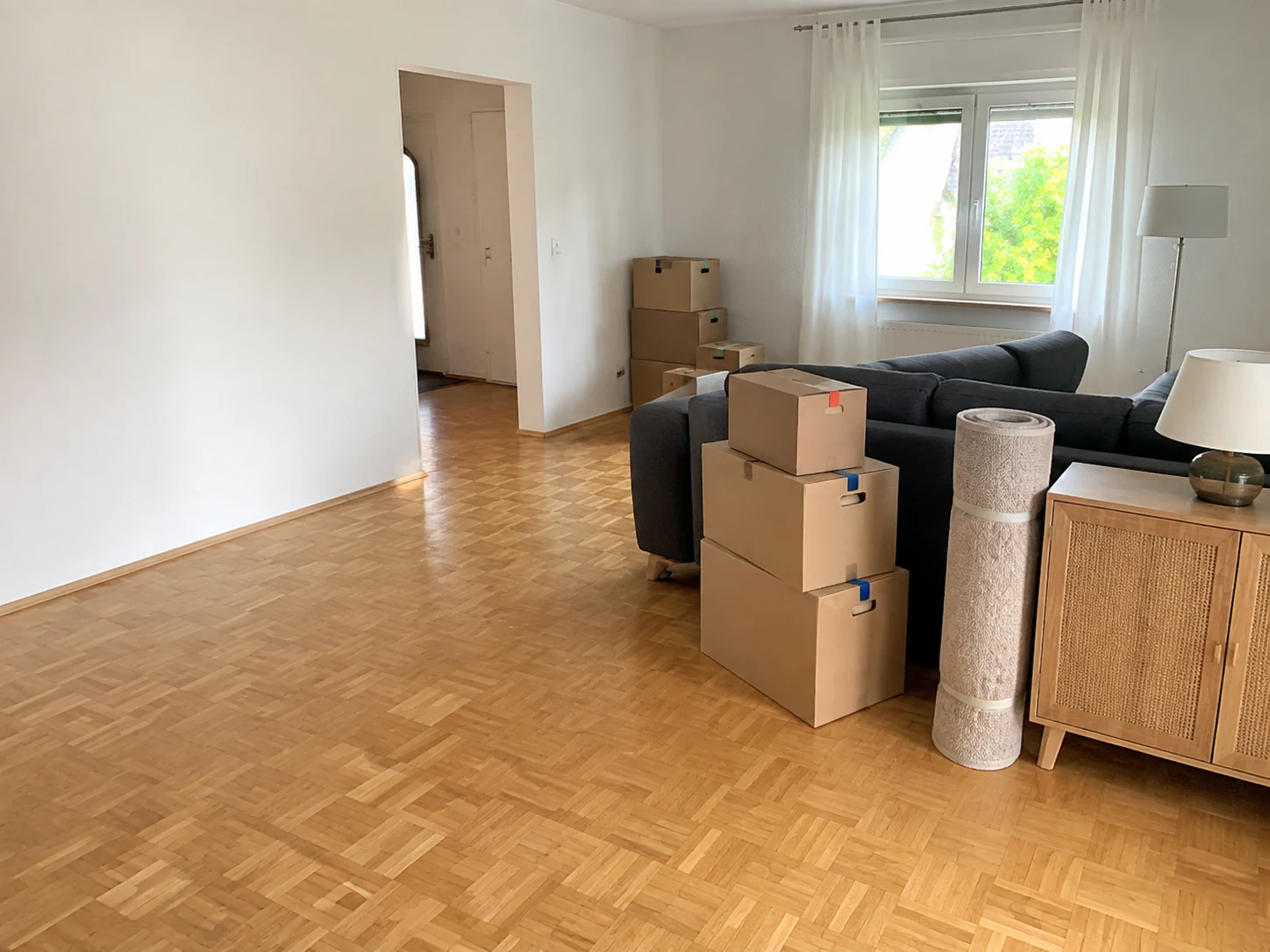 Wohnraum mit Möbeln und Kartons für eine Haushaltsauflösung