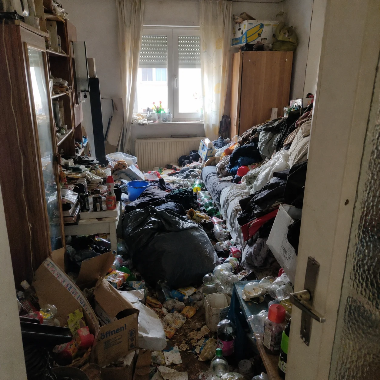 Stark zugestelltes Zimmer vor einer Messie-Entrümpelung